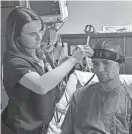  ?? NICOLE VILLALPAND­O/ AUSTIN AMERICAN-STATESMAN ?? Matthew Hallahan’s nurse demonstrat­es how she can put on the device to monitor his seizures using AI.