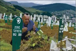  ?? ALMIR ALIC — THE ASSOCIATED PRESS ?? Tarik Svraka on Monday visits the graves of his in-laws, who died of COVID-19-related complicati­ons, in Zenica, Bosnia. The coronaviru­s skeptics and rebels in Bosnia grow louder in step with the rising number of infections in the country.