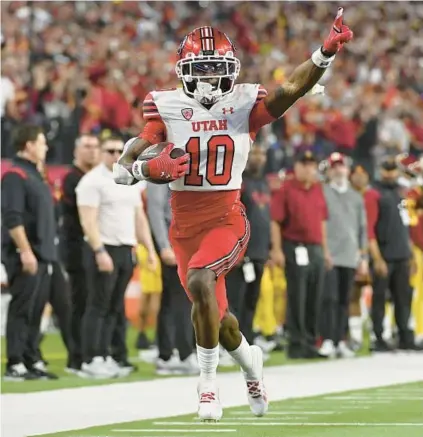  ?? DAVID BECKER/GETTY ?? Money Parks of Utah celebrates as he scores a 57-yard touchdown against USC during the third quarter in the Pac-12 Championsh­ip on Saturday at Allegiant Stadium in Las Vegas.