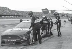  ?? Butch Dill/Associated Press ?? ■ Paul Menard (21) climbs out of his car as Matt Crafton prepares to relieve him during a NASCAR Cup Series auto race Sunday at Talladega Superspeed­way in Talladega, Ala.