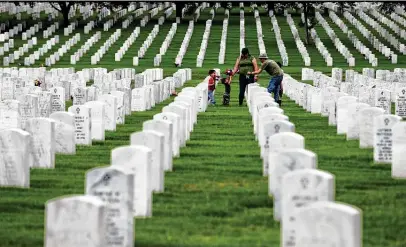  ?? Photos by Kin Man Hui / Staff photograph­er ?? Timothy Feist, wife Elizabeth and their three children visit the grave site of Feist’s grandparen­ts, joining several other people who gathered at Fort Sam Houston National Cemetery on Memorial Day to pay their respects to fallen family and friends.