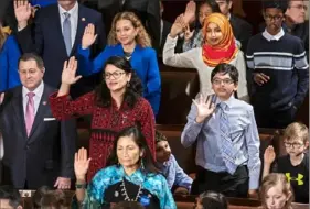  ?? J. Scott Applewhite/Associated Press ?? Democratic members of the House take their oaths. Ms. Omar is in the top row, wearing a hijab, and Ms. Tlaib is second from the left in the middle row.