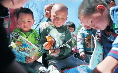  ?? PHOTOS BY WANG JING / CHINA DAILY ?? Youngsters in the southweste­rn province of Guizhou read books donated by volunteers.