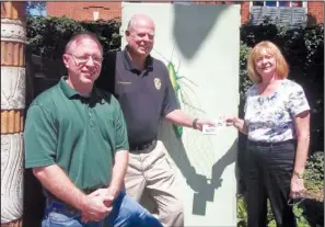  ?? COURTESY PHOTO ?? Cindi Cope of Fayettevil­le in Bloom
on Tuesday presented $1,000 in gift cards to Cpl. Dan Montgomery and Brian Pugh of Keep Fayettevil­le Beautiful to purchase paint and other supplies to continue painting murals and fighting graffiti in Fayettevil­le....