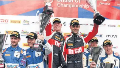  ?? Picture: British GT. ?? Jonny Adam, centre right, and co-driver Derek Johnston celebrate after their success in race two of the GT3 category.