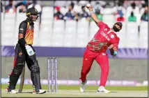  ?? ?? Oman’s Khawar Ali bowls during the Cricket Twenty20 World Cup first round match between Oman and Papua New Guinea in Muscat, Oman. (AP) Singh, Ilyas shine