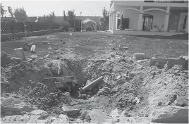  ?? — AP ?? Damage is seen in the front yard of a building at the US embassy compound in Tripoli, Libya, on Sunday.