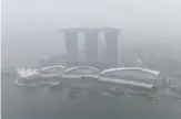  ?? —AFP ?? SINGAPORE: This overview shows the Marina Bay Sands hotel and resort blanketed by haze in Singapore yesterday.