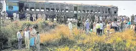  ?? PTI FILE ?? People gather near the burnt bogies of the Samjhauta Express that caught fire following explosions near Panipat in Haryana in 2007.