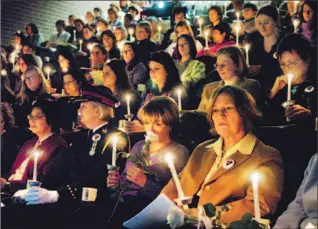  ?? RICHARD LAUTENS/TORONTO STAR ?? Marilyn Churley, former NDP women’s issues critic, smells a rose at a Montreal Massacre memorial service. Churley is flanked by Deputy Police Chief Jane Dick, left, and author Stevie Cameron, right.