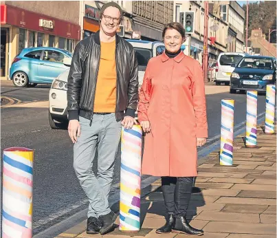  ?? Picture: Tina Norris. ?? Artists Caspar Wilson and Nicola Atkinson with their colourful bollards.