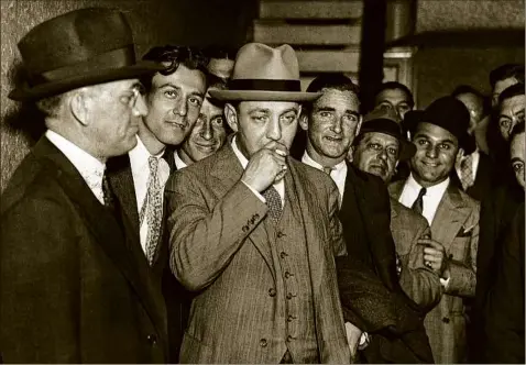  ?? Bettmann via Getty Images ?? Dutch Schultz, a bootlegger and racketeer, is shown in 1935 smoking a cigarette in front of New York Federal Court. Schultz's crime infiltrate­d into labor unions from the early 1930s until he was gunned down Oct. 23, 1935.