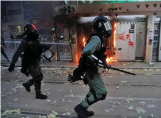  ??  ?? SPIRALLING VIOLENCE: Hundreds of people in Hong Kong staged a sit-in on Wednesday outside the school of an 18-year-old protester who remains in hospital after being shot by police.