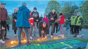  ?? ?? Stopping along the way to light candles at the 2019 walk.