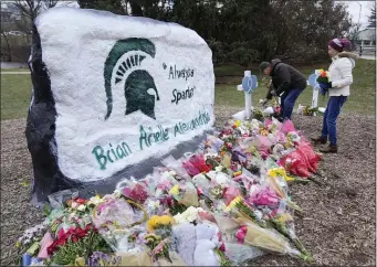  ?? AP PHOTO/PAUL SANCYA ?? Mourners leave flowers at The Rock on the grounds of Michigan State University in East Lansing, Mich., Wednesday, Feb. 15, 2023.