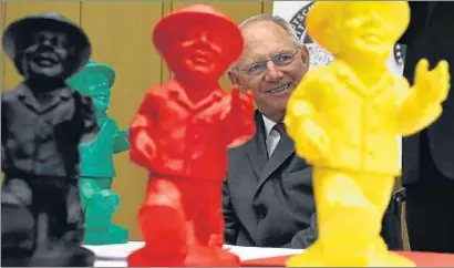  ?? TOBIAS SCHWARZ / AFP ?? El ministro de Finanzas, Wolfgang Schäuble, con las esculturas de colores inspiradas en el Ampelmann