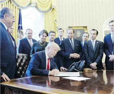  ?? OLIVIER DOULIERY / GETTY IMAGES ?? U. S. President Donald Trump, at the White House on Friday, signs an executive order establishi­ng regulatory reform officers and task forces within federal agencies.