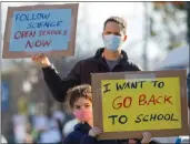  ?? ANDA CHU — BAY AREA NEWS GROUP ?? Asaf Bar-Tura and daughter Alma, 7, a first grader, protest along Solano Avenue near the Albany Unified School District Student Enrollment Center in Albany, on February, 10, 2021.