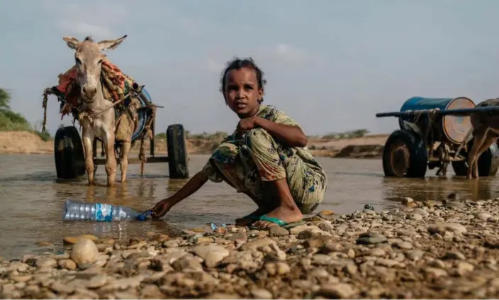  ?? Photograph: Eduardo Soteras/AFP/Getty Images ?? A girl collects water from the Shebelle River in Gode, Ethiopia, in 2022, during the worst drought to hit the Horn of Africa for 40 years.