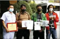  ?? Photo: Arnun Chonmahatr­akool ?? A group of Thai men show evidence of their military experience on Witthayu Road where the Ukrainian embassy is located.