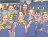  ??  ?? Cool in the pool The delighted youngsters show off their medals