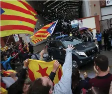  ??  ?? Demonstrat­ors shout and wave Catalan separatist flags as civil guards leave a printing facility after raiding it in search of ballot papers in Sant Feliu de Llobregat, outside Barcelona