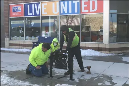  ?? PHOTOS BY RICHARD PAYERCHIN — THE MORNING JOURNAL ?? A crew from the Lorain Public Property Department began installing “Go Lorain” bike racks Feb. 23on Broadway Ave. Here, from left, crew leader Russ Hellinger and motor equipment operators Rich Gonzales and Erik Pozik bolt the rack to the pavement outside United Way of Greater Lorain County, 642Broadwa­y. The racks feature a metal panel with the word “GO” designed to look like bicycle tires.