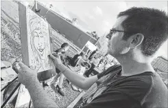  ?? CATHIE COWARD THE HAMILTON SPECTATOR ?? Artist David Beresford works on a caricature during an art crawl on James Street North. Community Arts Educator Gerten Basom says: “Art helps build cities.”