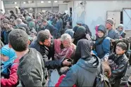  ?? SANA VIA AP ?? This photo released by the Syrian official news agency SANA shows Syrian civilians with their belongings as they flee from fighting between the Syrian government forces and rebels, near Hamouria in eastern Ghouta, a suburb of Damascus, Syria, on Friday.