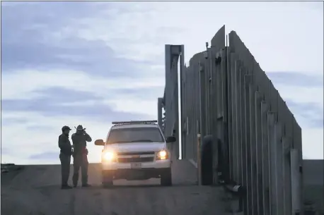  ?? GREGORY BULL — THE ASSOCIATED PRESS ?? U.S. Border Patrol agents near one of the border walls separating Tijuana, Mexico and San Diego. The ACLU has filed 174 lawsuits dealing with immigrant rights.