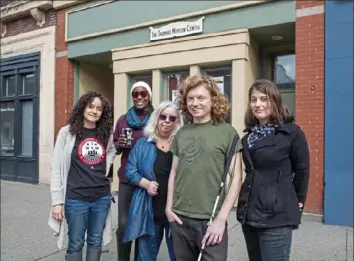  ?? Andrew Rush/Post-Gazette photos ?? Staff members of the Thomas Merton Center stand outside the organizati­on's Penn Avenue office in Garfield on Thursday. From left: Krystle M. Knight, director of organizing; Sheryland Neal, tech-ops coordinato­r; Roslyn Maholland, finance director; Gabriel McMorland, executive director; and board member Symone Saul.