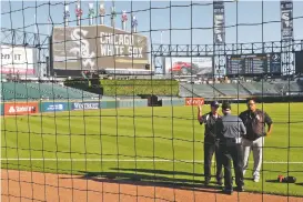  ??  ?? Security personnel at Guaranteed Rate Field are viewed Monday through the newly extended protective netting along left field before the game.
