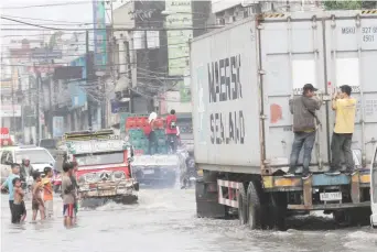  ??  ?? FLASH FLOOD – A heavy downpour brought about by a lowpressur­e area flooded several streets in Mandaue City Sunday. (Juan Carlo de Vela)