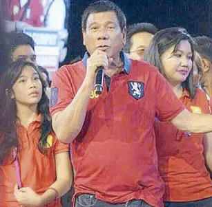  ??  ?? “Red was the lucky color of Rody during all his past election campaigns,” says wife Honeylet Avanceña, with daughter Kitty Duterte during his miting de avance.