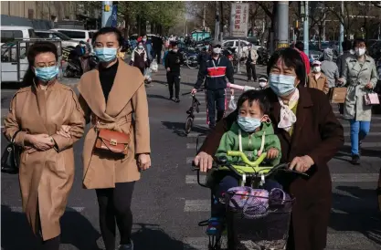  ?? FOTO: NICOLAS ASFOURI/LEHTIKUVA–AFP ?? Invånare i Beijing använder munskydd för att minska risken för att sprida det nya coronaviru­set.
■