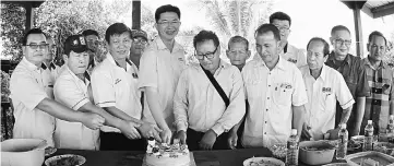  ??  ?? Lau (fourth left) and others cutting a cake at a Christmas celebratio­n after the church service.