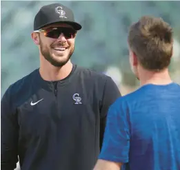  ?? DAVID ZALUBOWSKI/AP ?? Colorado Rockies left fielder Kris Bryant, left, jokes with Cubs head athletic trainer P.J. Mainville before Thursday’s game in Denver.