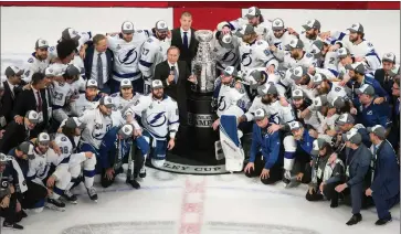  ?? Canadian Press photo ?? Tampa Bay Lightning players surround NHL Commission­er Gary Bettman as they celebrate after defeating the Dallas Stars to win the Stanley Cup in Edmonton on Monday.