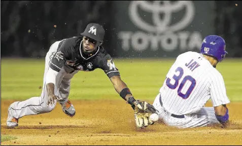  ?? CHARLES REX ARBOGAST / ASSOCIATED PRESS ?? The Cubs’ Jon Jay steals second past Marlins second baseman Dee Gordon during Tuesday’s fifth inning. Chicago scored four runs in the fifth and added six runs in the seventh.