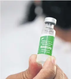  ?? REUTERS ?? A health worker holds a vial with doses of the Oxford-AstraZenec­a Covid-19 vaccine, marketed as Covishield, in Suriname, on Tuesday.