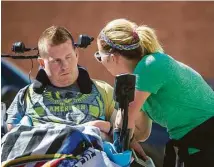  ??  ?? Danielle encourages Nick, who seems inattentiv­e, to keep working with his motorized wheelchair in the TIRR Memorial Hermann parking lot.