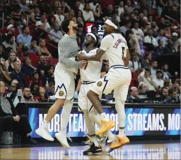  ?? REBECCA BLACKWELL — THE ASSOCIATED PRESS ?? Nuggets guards Jamal Murray, left, Reggie Jackson and Kentavious Caldwell-pope celebrate during the second half against the Heat on Wednesday in Miami.