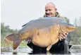  ??  ?? Wayne Mansford with his catch: a 75lb 2oz imported mirror carp, nicknamed Marshall