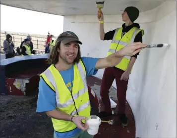  ??  ?? Al Collins and Ryan Kealy from the Bray Skateboard­ing Associatio­n paint a seafront shelter