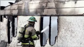  ?? Doug Walker / Rome News-Tribune ?? Rookie firefighte­r Cade Bradley pours water into the storage room at 515 Superba Ave. on Tuesday. The blaze apparently started in the back storage room and spread into the house.