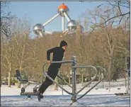  ?? (File Photo/AP/Francisco Seco) ?? A man exercises Feb. 9 at a public gym next to the Atomium after a snowfall at a park in Brussels.