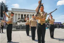  ?? Jacquelyn Martin / Associated Press ?? U.S. Navy Ceremonial Guard practice with M19 rifles by a Bradley Fighting Vehicle in front of the Lincoln Memorial.