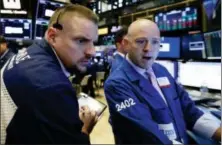  ?? RICHARD DREW — THE ASSOCIATED PRESS FILE ?? Trader Michael Milano, left, and specialist Jay Woods work on the floor of the New York Stock Exchange.
