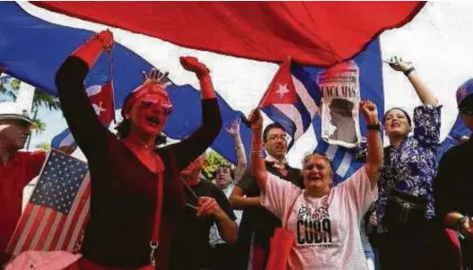  ?? Joe Raedle / Getty Images ?? People in Miami celebrate the news of Cuban revolution­ary Fidel Castro’s death. In death as in life, the dictator elicited different emotions among Cubans.