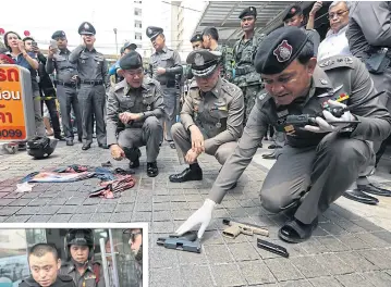  ??  ?? ABOVE Police inspect the area outside a gun shop in Bangkok’s Phra Nakhon district after four Mongolian suspects were shot by police in a botched gun shop heist. The shooting left two suspects injured and one dead.